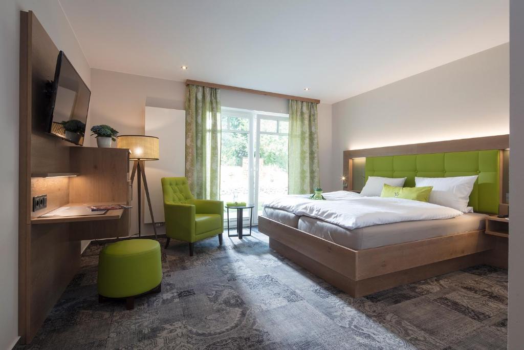 a bedroom with a bed and a desk and a chair at Landhotel Witte-König in Garrel