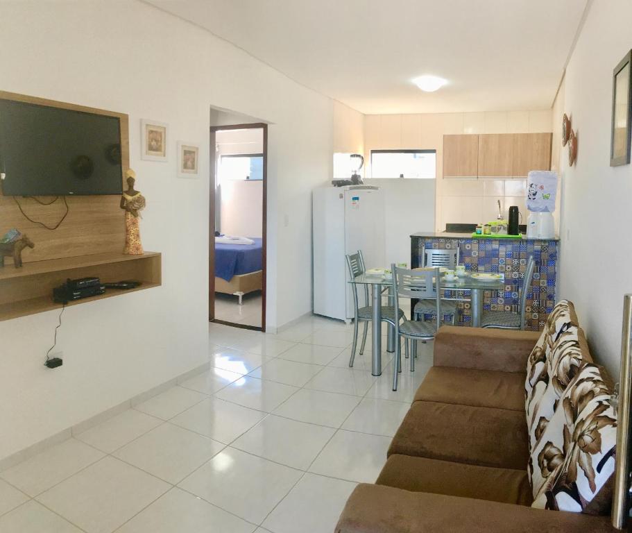 sala de estar y cocina con sofá y mesa en Maragogi Praia Flats, en Maragogi