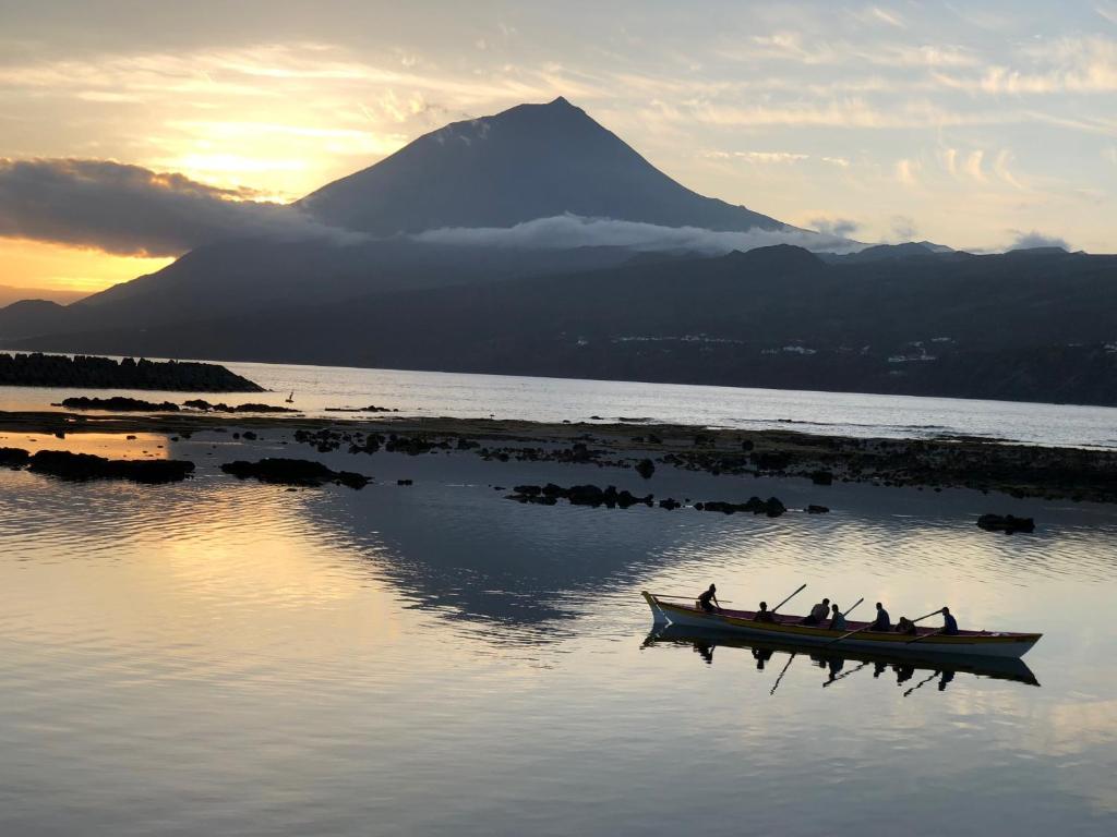 a group of people in a boat on a body of water at casa da rochinha in Lajes do Pico