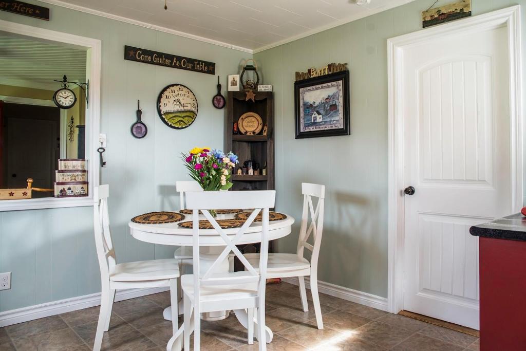 a dining room with a white table and chairs at Mama`s By The Sea B&B in Clark's Harbour