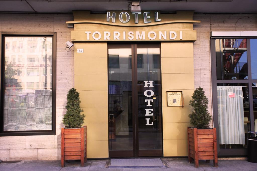 een hoofdingang van het hotel met twee planten ervoor bij Hotel Torrismondi in Cuneo