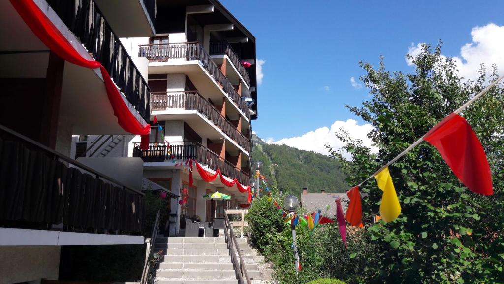 un bâtiment avec des drapeaux sur son côté dans l'établissement Village vacances Le Savoy, au Grand-Bornand
