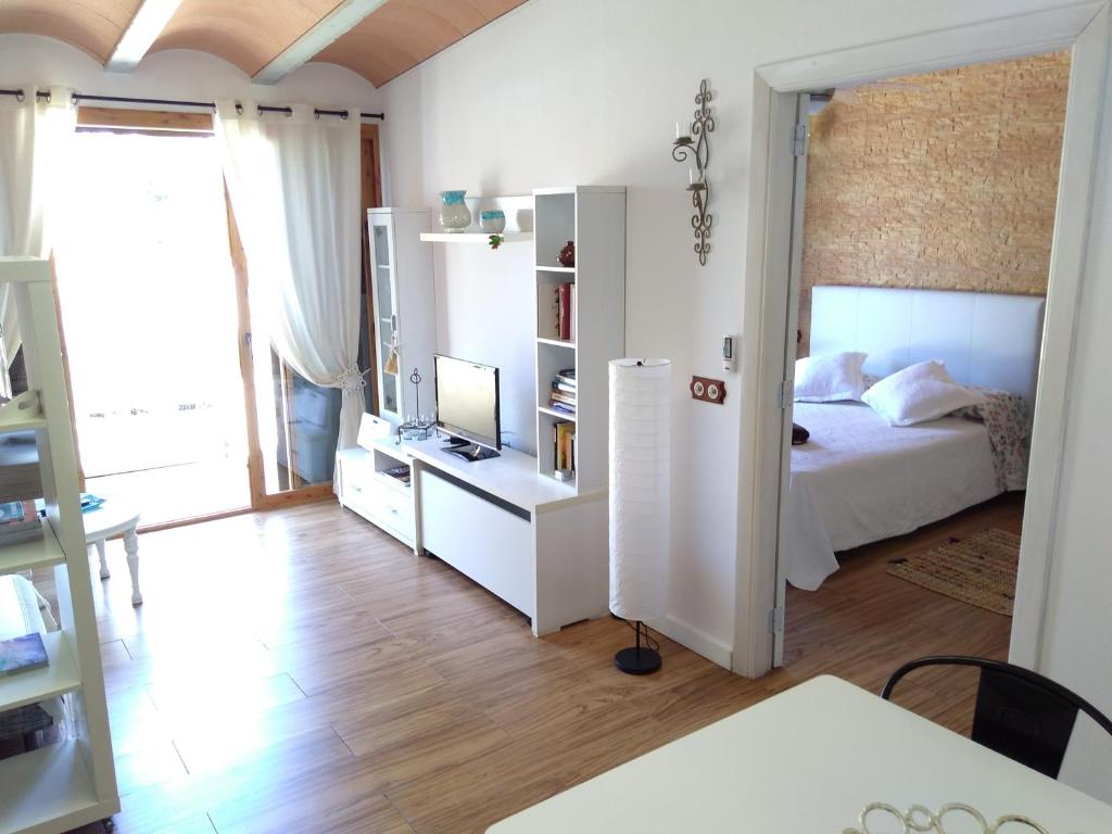 a bedroom with a bed and a desk with a television at can jaume portas in Sant Francesc Xavier