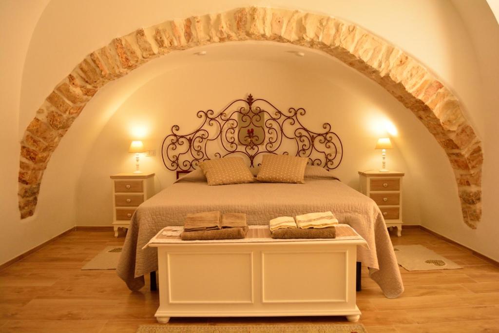 una camera con letto e testiera decorata di ESCIA' b&b a Noci