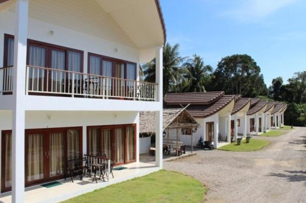 una fila de edificios con mesas y sillas en el patio en Naga Peak Resort, en Ao Nang Beach