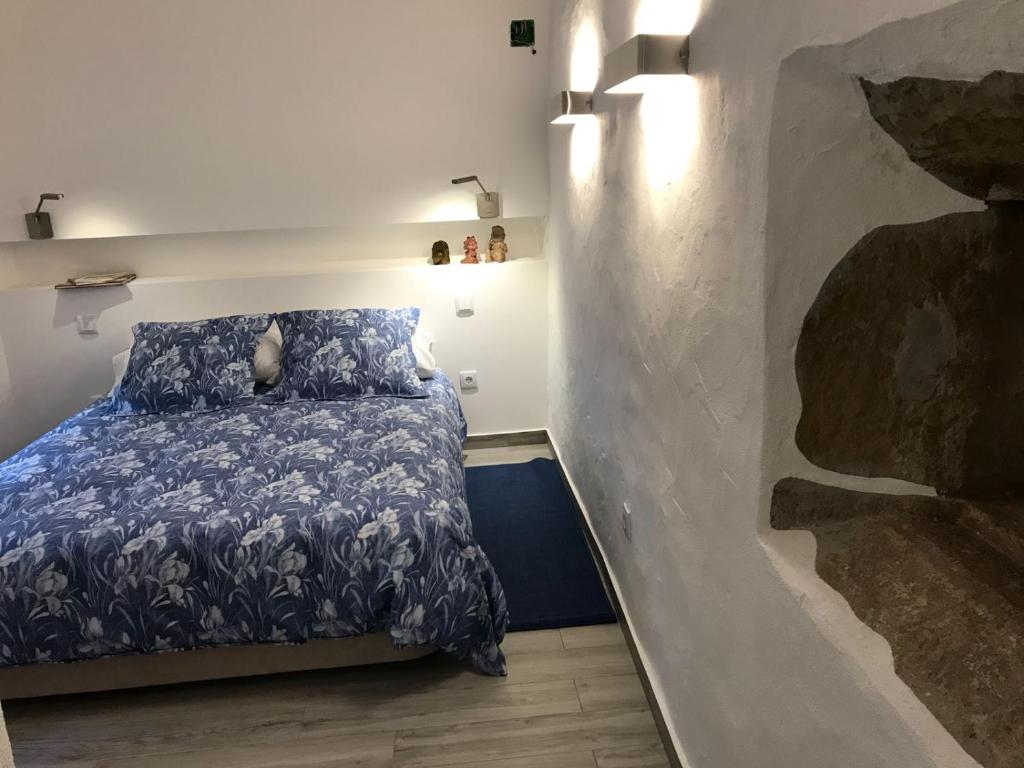 um quarto com uma cama com um edredão azul em A Gosto em Tomar