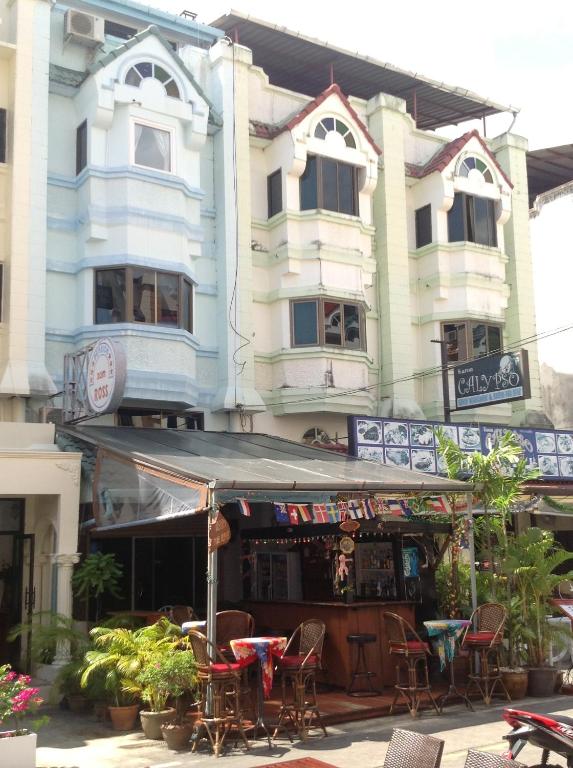 a building with tables and chairs in front of it at Pension Zum Ross in Karon Beach