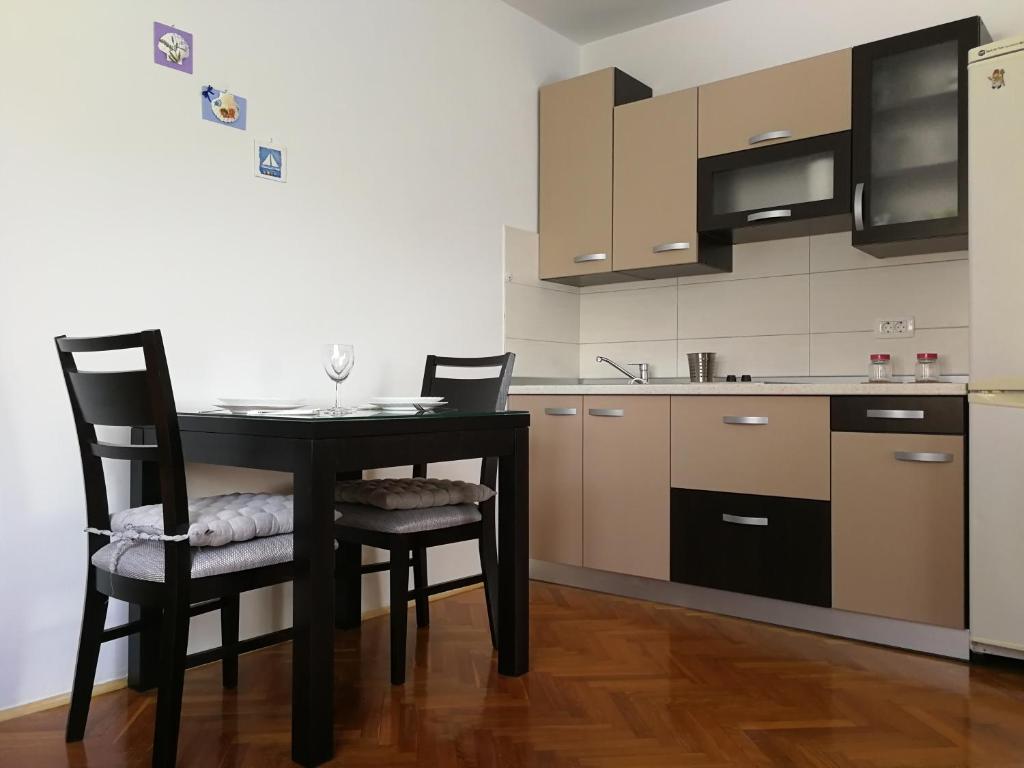 a kitchen with a black table and two chairs at Apartment Violeta 2 in Funtana