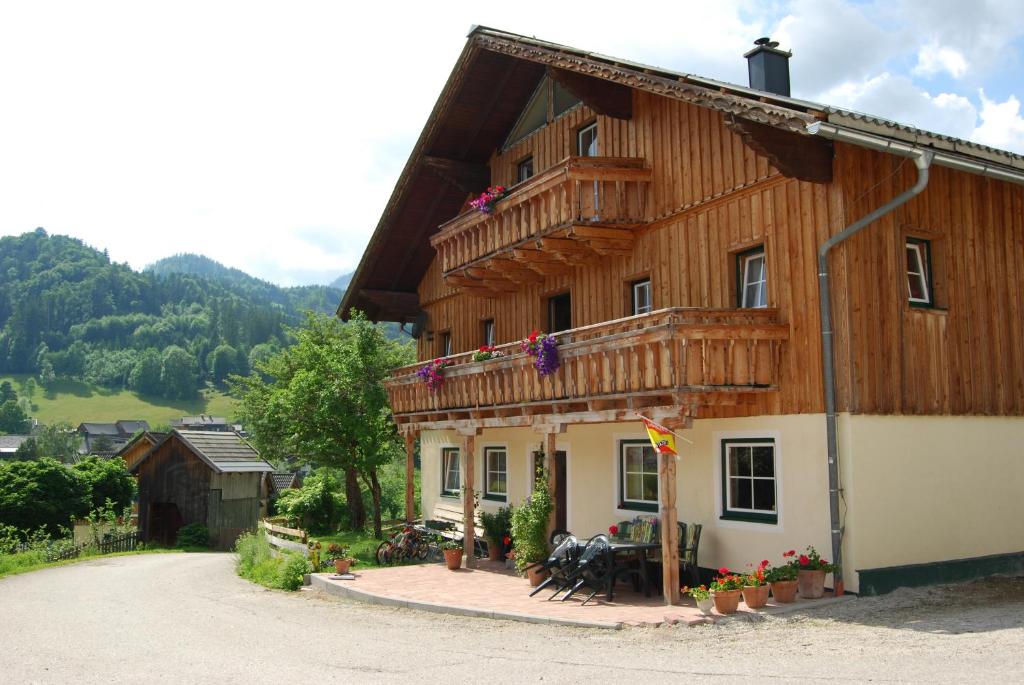 a wooden house with a balcony on the side of it at Reitbauernhof Schartner in Altaussee