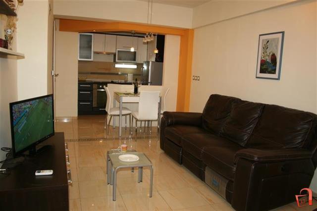 a living room with a brown couch and a table at Utopia Apartments Ohrid in Ohrid