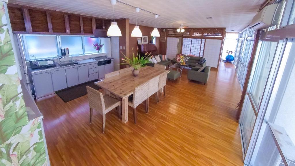 a living room with a wooden table and a kitchen at Tomonoya Ishigaki in Ishigaki Island