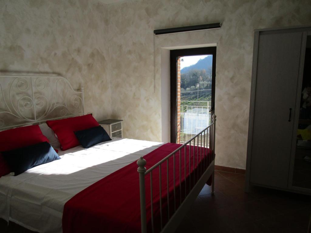 a bedroom with a bed with a large window at Alla Contrada degli Asinelli in Colledanchise