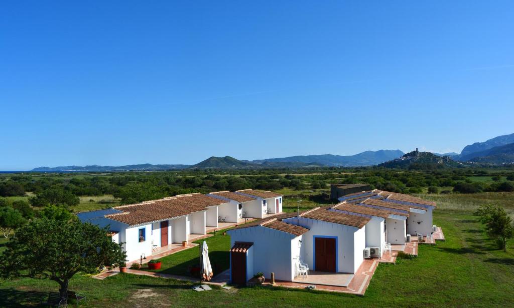 eine Reihe weißer Häuser mit Bergen im Hintergrund in der Unterkunft Agriturismo Orvile in Posada