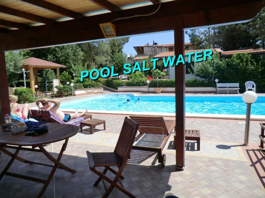 a group of people sitting around a table by a swimming pool at VILLASEASICILY or VILLA Sea And Archaeology in Balestrate