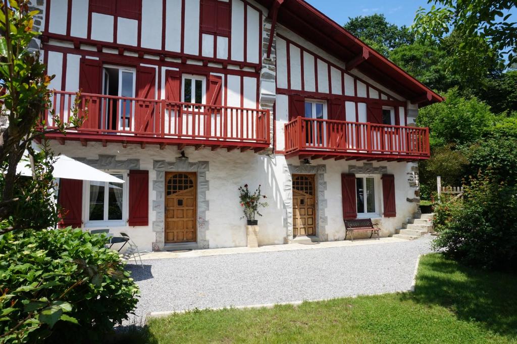 a house with red balconies on the side of it at studio Eder Enea in Cambo-les-Bains