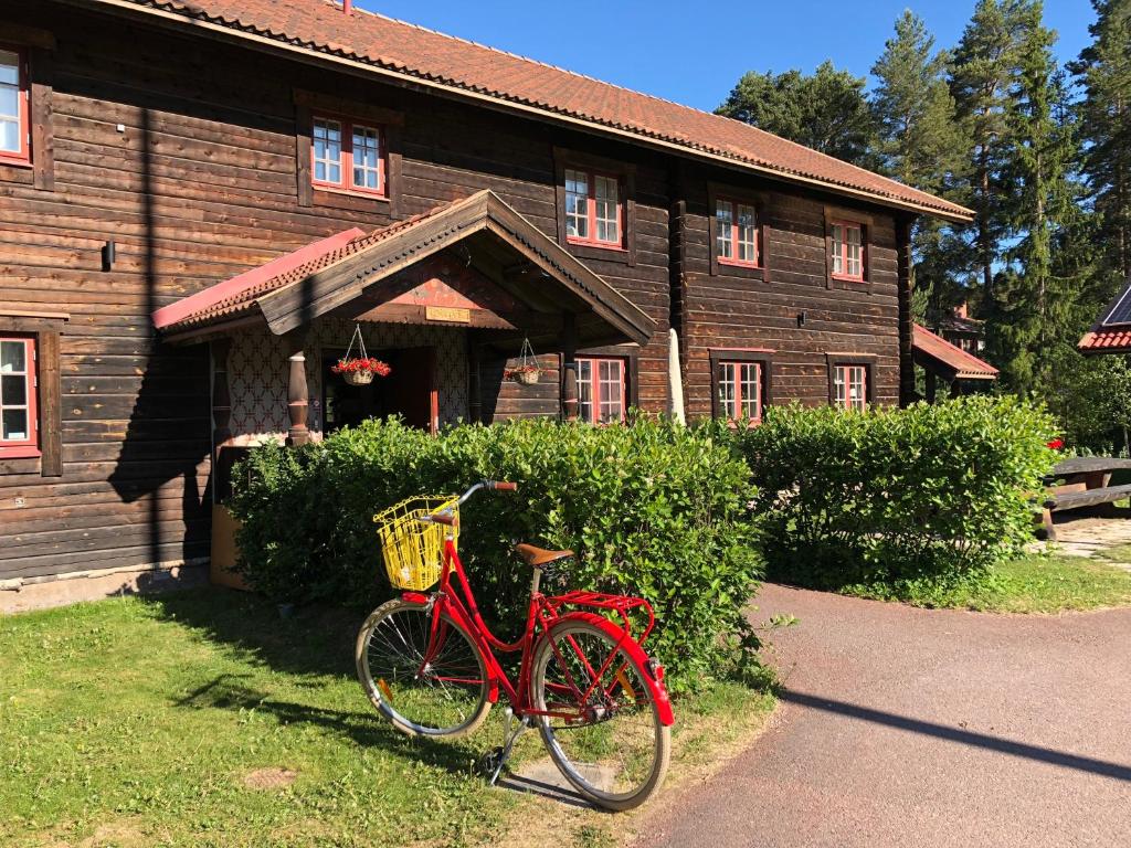 una bicicleta roja estacionada frente a un edificio en Rättviksgårdens Vandrarhem, en Rättvik