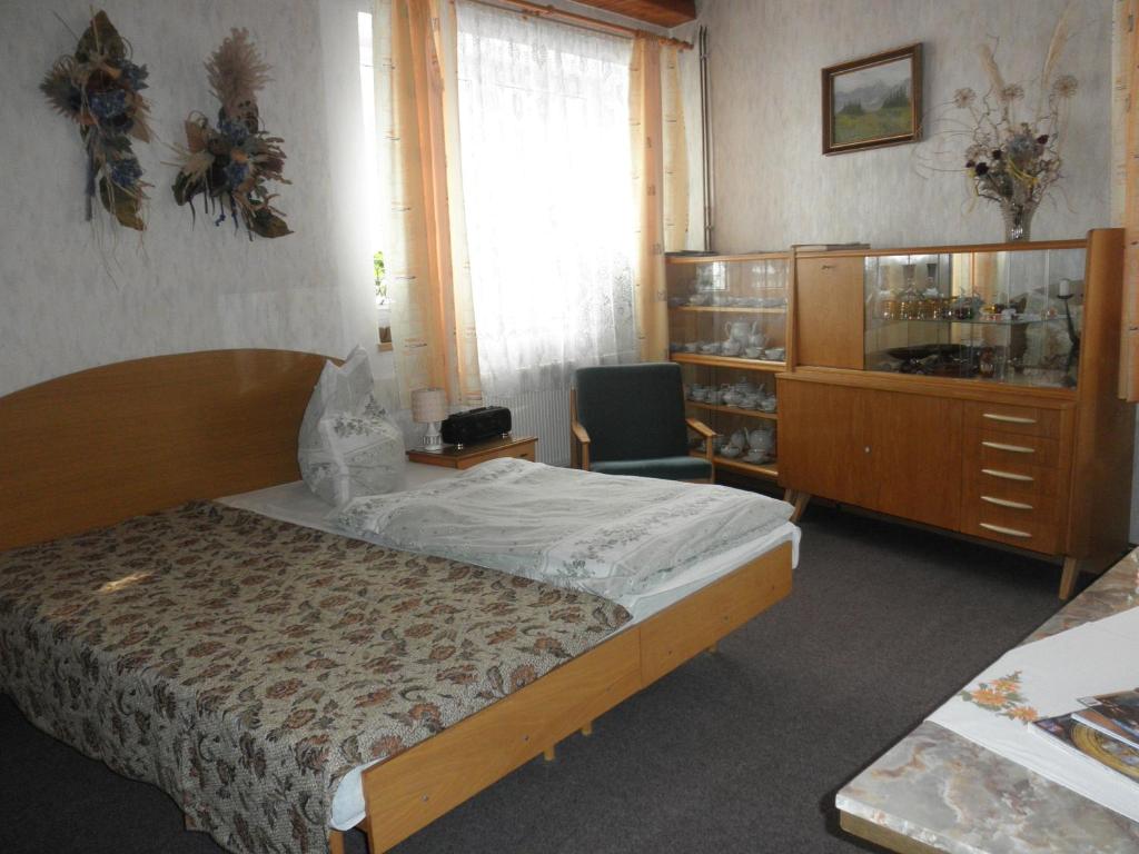 a bedroom with a bed and a cabinet and a window at Pension U Kaktusu in Karlovy Vary