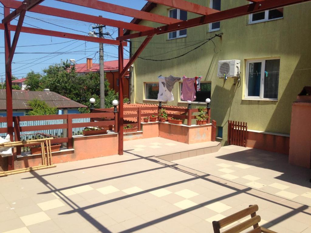 ein Gebäude mit einer Terrasse mit einer Bank darauf in der Unterkunft Villa Cristina in Mangalia