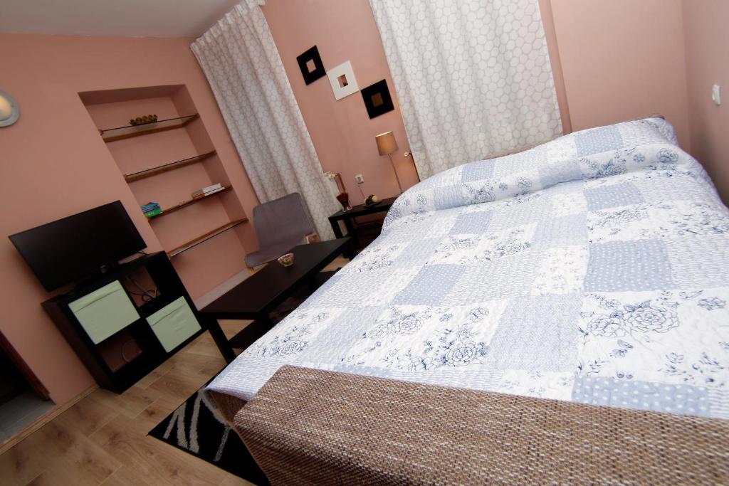 um quarto com uma cama com uma colcha azul e branca em Apartment house Lalita em Fuzine