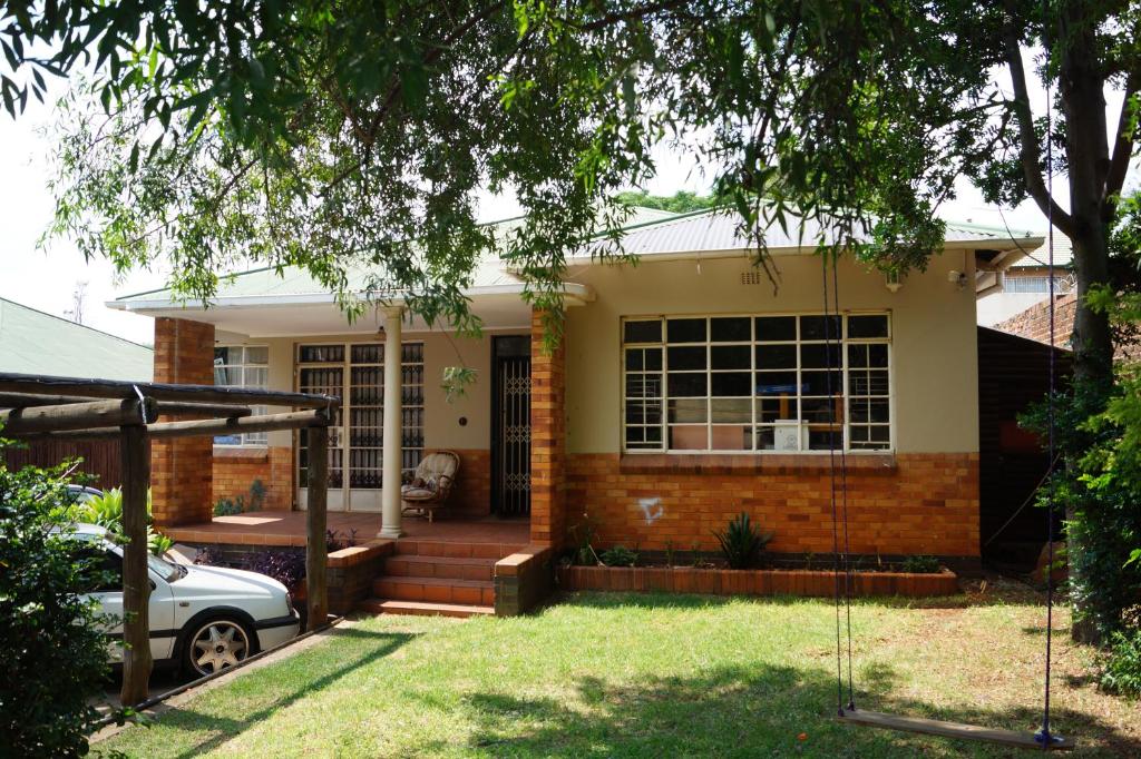 une maison avec une balançoire dans la cour dans l'établissement Westmoreland Lodge, à Johannesbourg