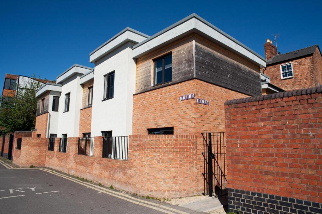 a red and white building with a brick wall at Quire Court Apartment in Gloucester