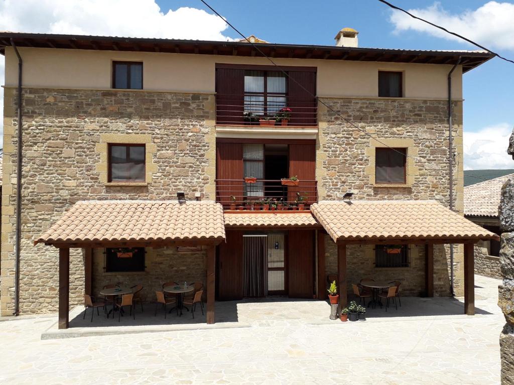 una vista esterna di un edificio con tavoli e sedie di Hospedería Prepirineo a Undués-Pintano