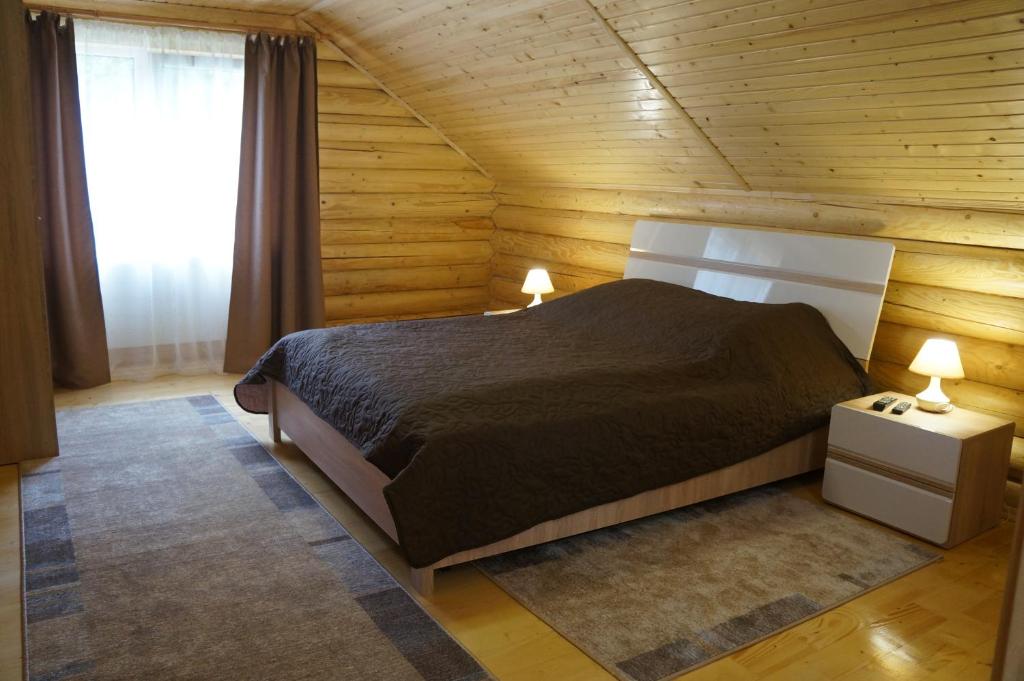 a bedroom with a bed in a wooden room at Guest House Smerichka in Shaian
