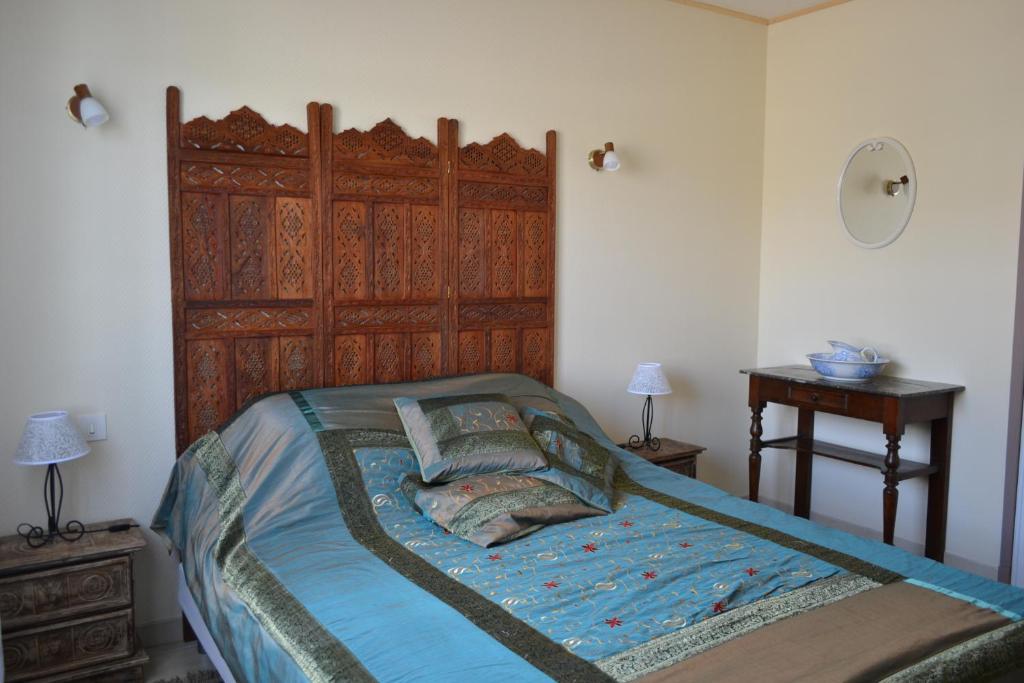 モンタニャックにあるGîte (Annexe de La perle de Ceylan)のベッドルーム1室(木製ヘッドボード付)