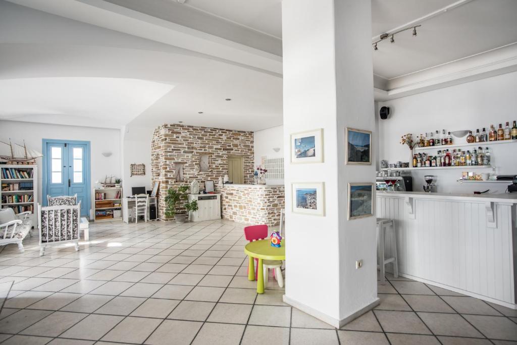 a living room with a yellow table and a brick wall at Hotel Mantalena in Antiparos Town