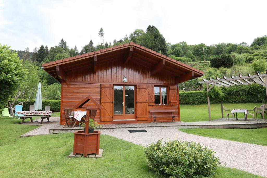 a small wooden cabin with a table and a bench at Chalet de Grettery in Saulxures-sur-Moselotte