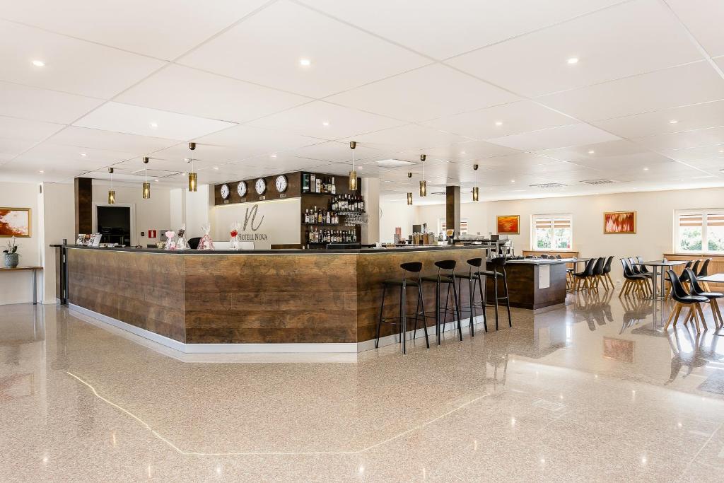 a large lobby with a bar and some chairs at Hotell Nova in Karlstad