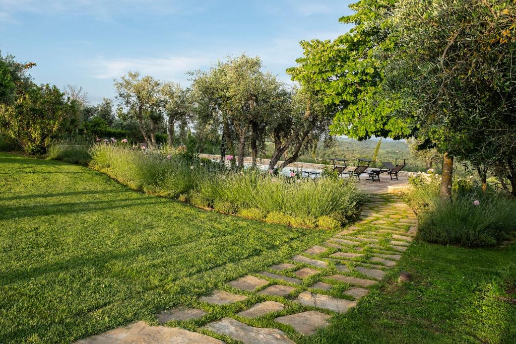 a garden with a stone path in the grass at Borgo Argiano in Castelnuovo Berardenga
