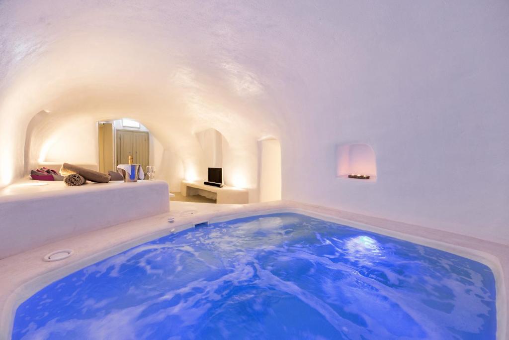 a large blue tub in a room with a bed at Kampanario Luxury Villa in Megalochori
