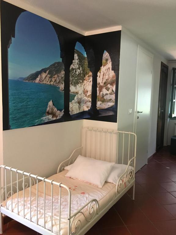 a bedroom with a bed with a painting on the wall at B&B Il Portico in Sarzana