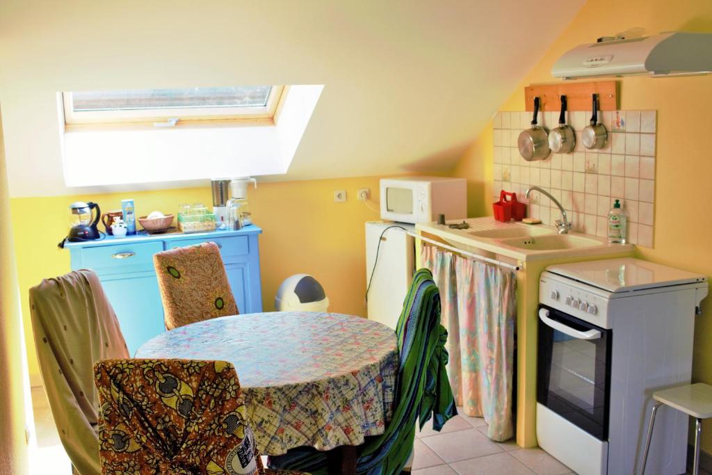 a small kitchen with a table and a sink at Au Temps de la Source in Raon-aux-Bois