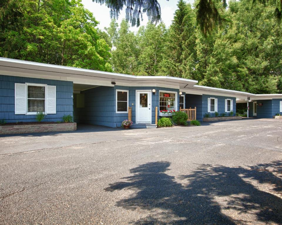 a blue house with a driveway in front of it at Whispering Winds Motel in Auburn