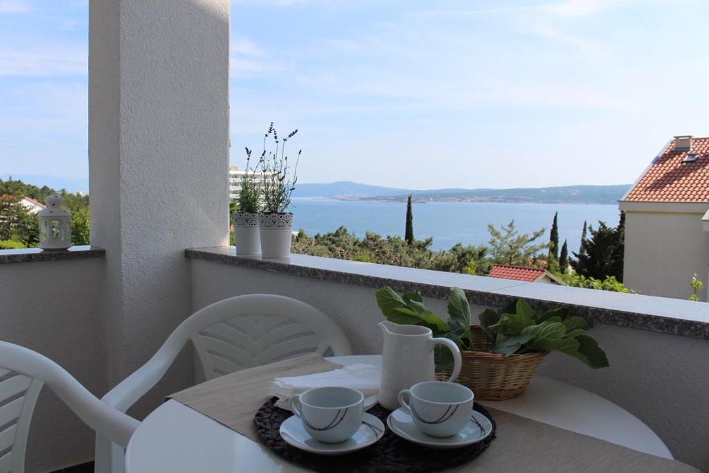 a table and chairs on a balcony with a view of the water at Mia 6 in Crikvenica