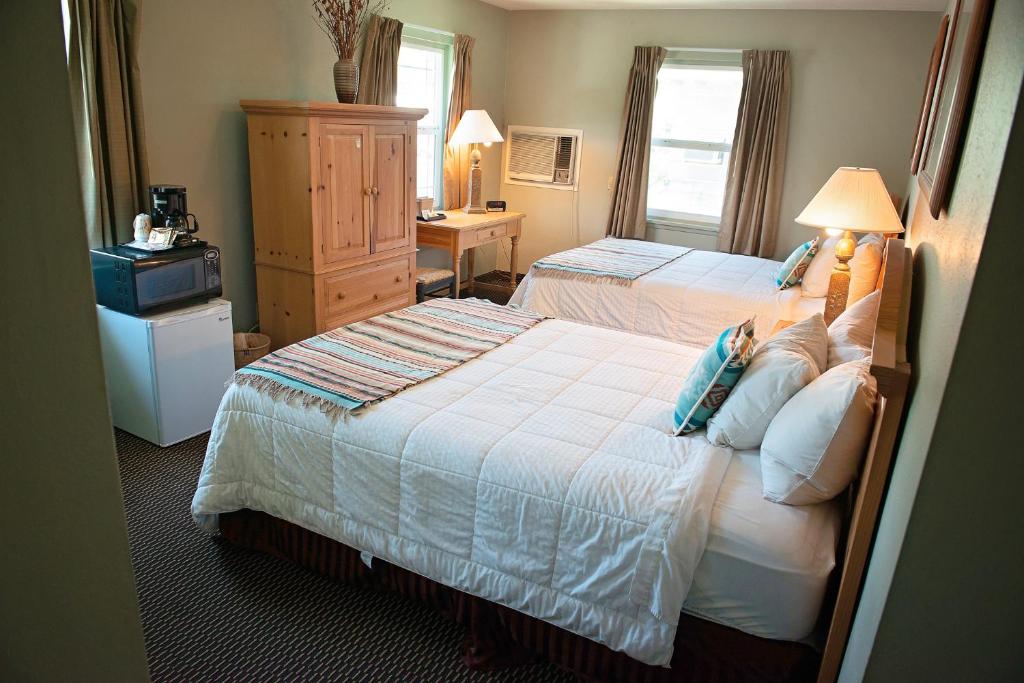 a hotel room with two beds and a television at Rugged Country Lodge in Pendleton