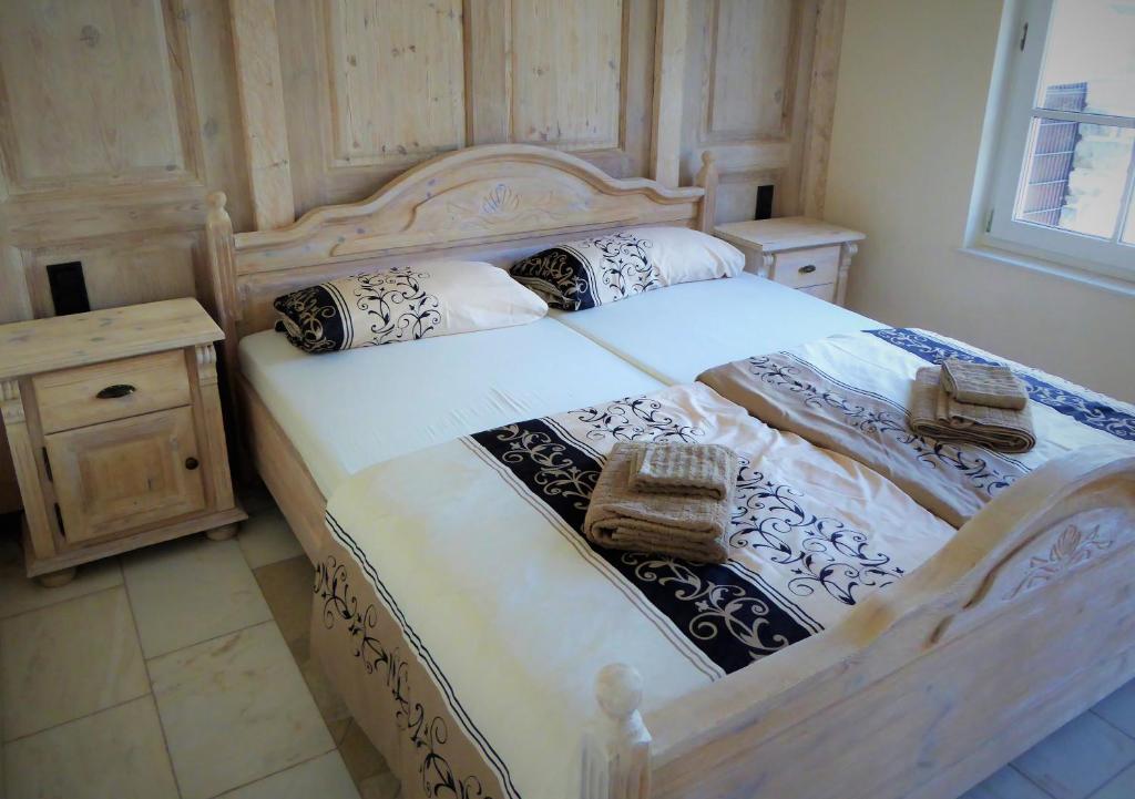 a bedroom with a large wooden bed with towels on it at Ferienhaus Waldernbach in Mengerskirchen