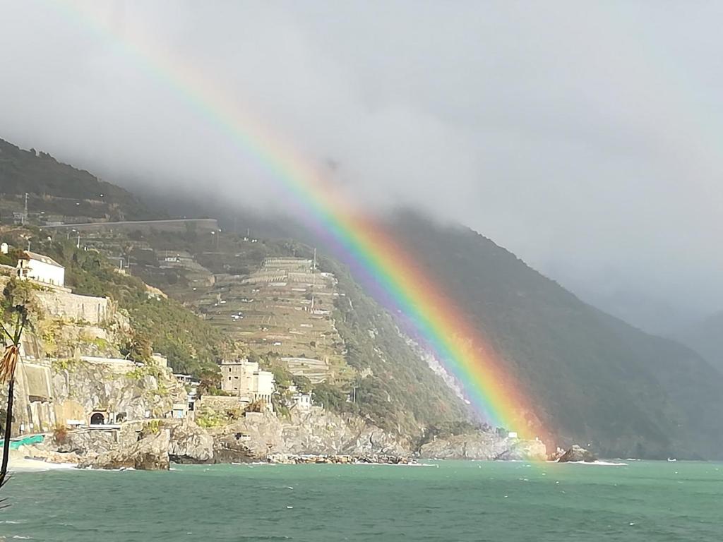 un arco iris sobre el agua junto a una montaña en Home by the Sea (Rainbow Home), en Monterosso al Mare