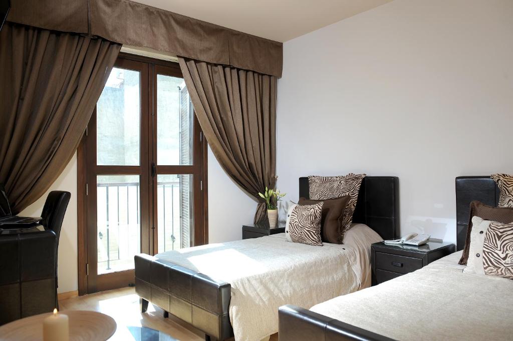 a bedroom with two beds and a window at Royiatiko Hotel in Nicosia