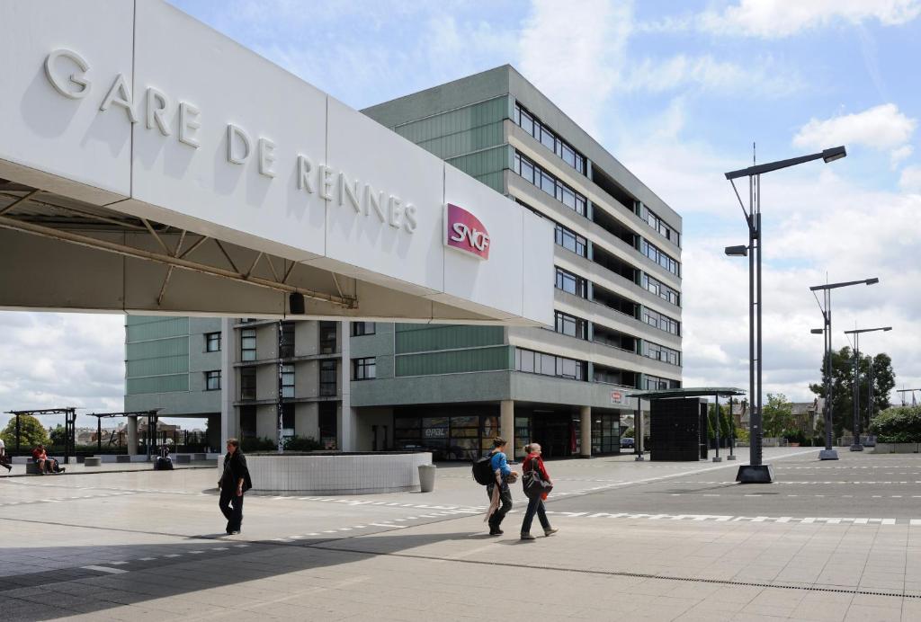 un groupe de personnes marchant devant un bâtiment dans l'établissement Séjours & Affaires Rennes de Bretagne, à Rennes