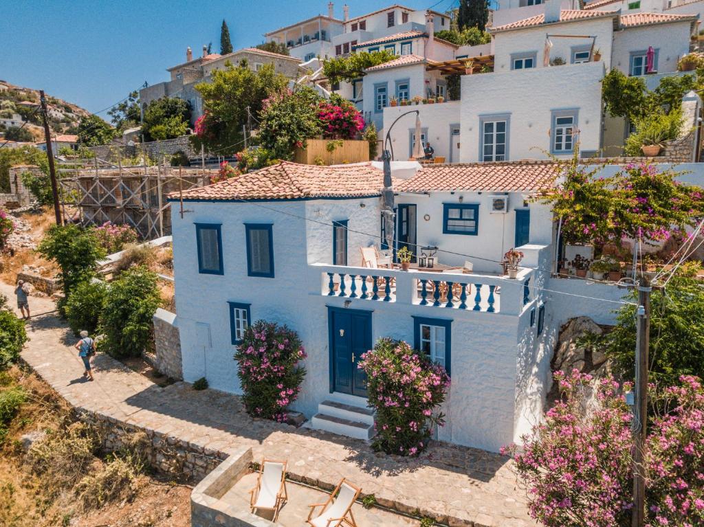 a white house on a hill with flowers at Lotus Sweet Home Hydra in Hydra