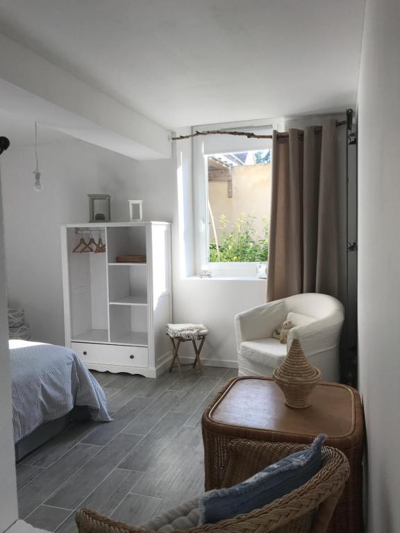 sypialnia z łóżkiem, krzesłem i oknem w obiekcie La petite maison w mieście Gasny