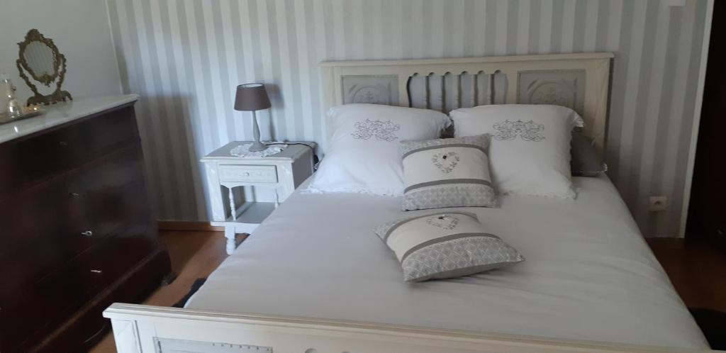 un letto bianco con due cuscini sopra di Casa san salvadore a Favalello