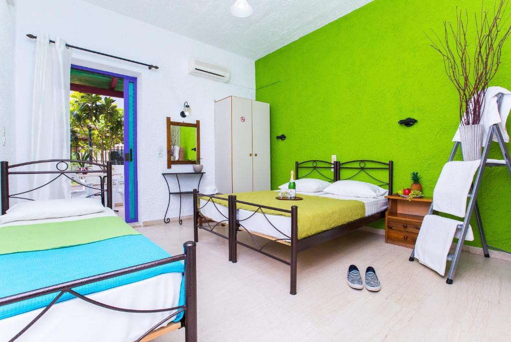a bedroom with two beds and a green wall at Litsa Studios in Malia
