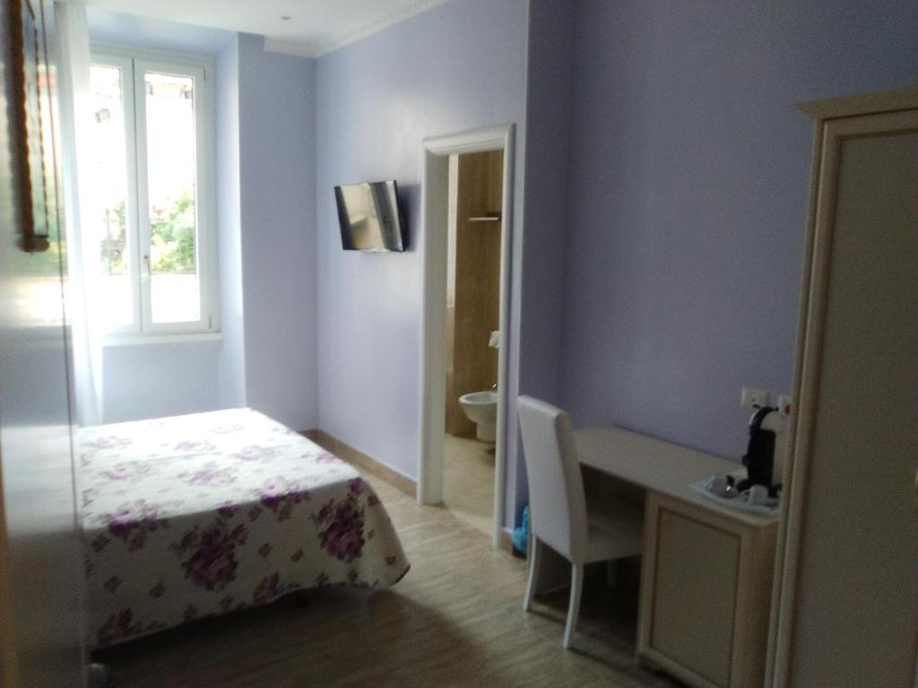 a bedroom with a bed and a desk and a window at Camere Ondina in Rome