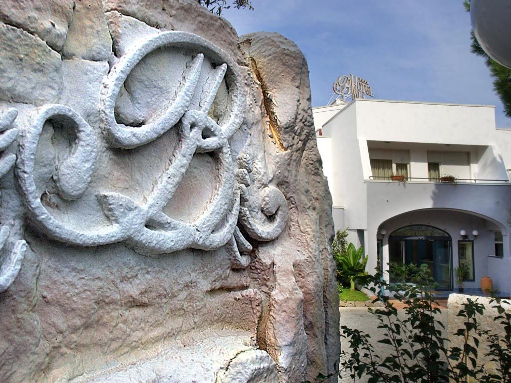 a stone wall in front of a building at Hotel Baia in Palinuro