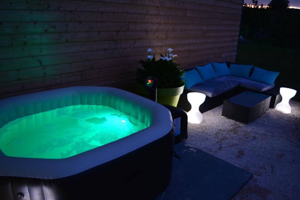 a jacuzzi tub in a backyard with a bench and a table at Rullyoloft in Rully