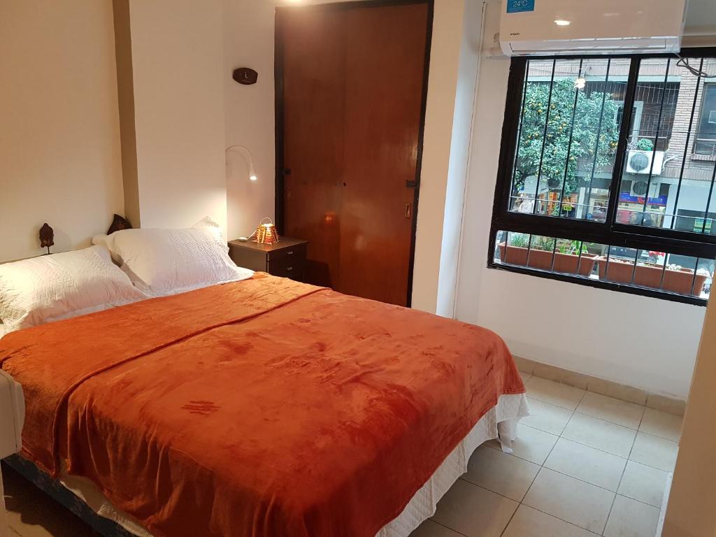 - une chambre avec un lit et une grande fenêtre dans l'établissement Ashram, à San Miguel de Tucumán